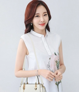 Detailed view of white sleeveless blouse with large pink floral print and a small stand collar