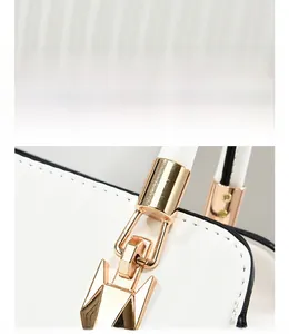 Detail of white textured leather handbag with premium light gold metal hardware and stitching