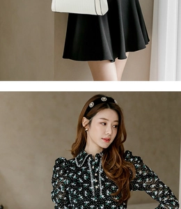 Detail of floral chiffon blouse with lace collar and high-waisted black midi skirt