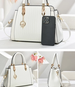 Detail of white pleated faux leather handbag with gold hardware and dancer charm