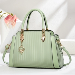 Elegant mint green pleated leather handbag with gold ballet charm and shoulder strap