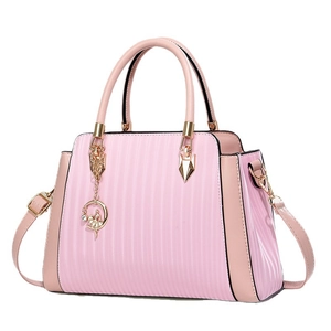 Sac à main élégant rose pâle avec rayures texturées et breloque ballerine dorée