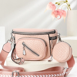 Detailed view of pink woven texture crossbody bag with a round coin pouch and patterned strap