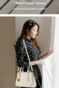 Close-up of cream handbag featuring premium gold zipper closure and clover charm detail