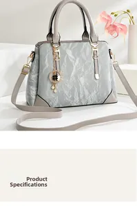 Close-up of pleated grey leather texture with a pearl clover charm and gold hardware