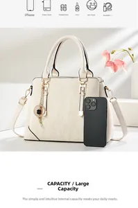 Detail view of large cream handbag capacity showing essentials like phone and cosmetics