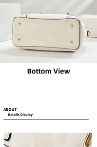 Close-up of cream textured tote bag bottom with gold metal protective feet and D-rings