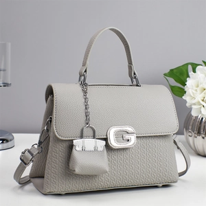 Elegant grey square handbag with diamond G logo and quilted details on white background