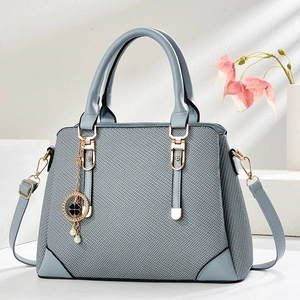 Light blue woven texture tote bag with gold hardware and pearl clover charm