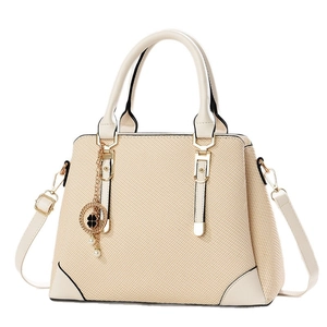 Minimalist cream woven tote bag with dual handles and elegant clover pearl charm pendant
