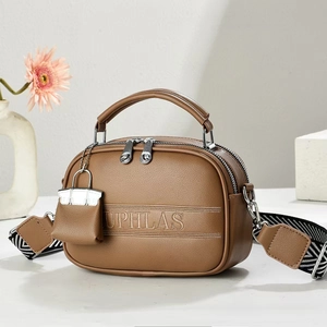 Brown litchi grain leather crossbody bag with wide geometric strap and mini charm