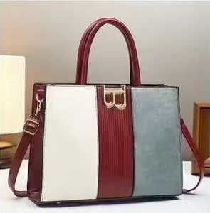 Detail of multi-color tote bag featuring a gold B-buckle and premium PU leather texture
