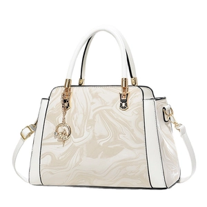 Elegant white tote bag with beige marble texture and gold ballerina charm ornament