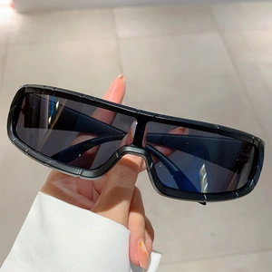 Detail of oversized sports sunglasses with black futuristic frames and seamless dark lens