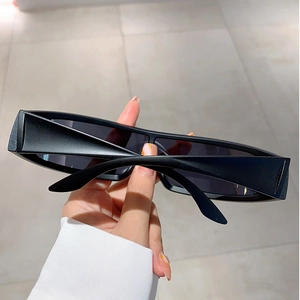 Close-up of matte black futuristic wrap-around sunglasses with a sleek punk design