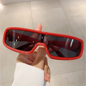 Detail view of red rectangular sports sunglasses with textured frame and dark UV lenses