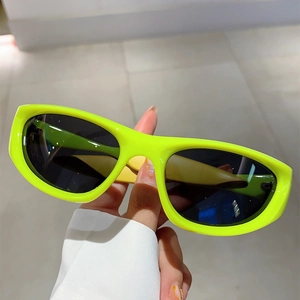 Detailed close-up of fluorescent yellow Y2K cycling sunglasses with dark lenses
