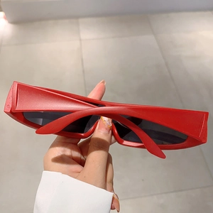 Close-up of red narrow rectangular sporty sunglasses with a futuristic cyberpunk aesthetic