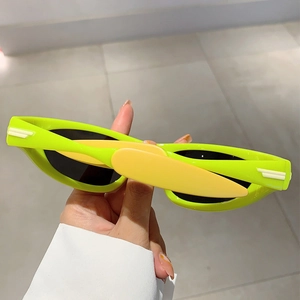 Macro detail of neon green Y2K sports sunglasses with orange temples and dark lenses