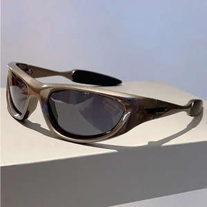 Close-up of Y2K sports sunglasses featuring champagne gold frames and dark grey lenses