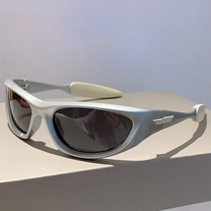 Side view of silver Y2K sports sunglasses with metallic wing decor and dark lenses
