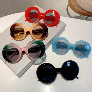 Retro round frame sunglasses in various colors displayed on modern geometric stands