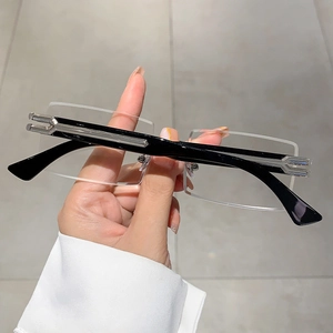 Detail of rimless rectangular sunglasses with black temples and silver metal hinges