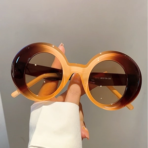 Close-up of retro round sunglasses showing gradient amber frame and model number 5610