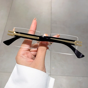 Detailed macro of rimless metal frame sunglasses with black and gold temples