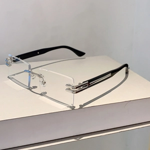 Detail of rimless rectangular sunglasses featuring silver metal hinges and black temples