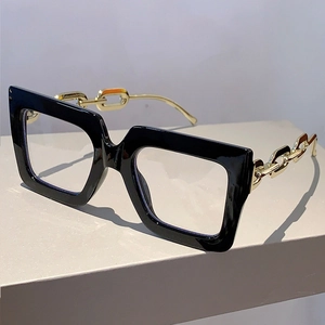 Detail of square oversized glasses with stylish gold chain temples and black frame