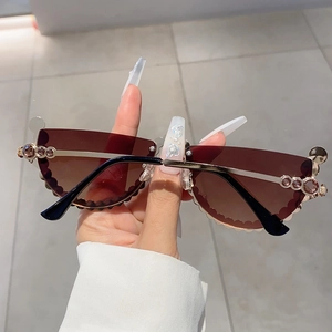 Close-up of cat-eye sunglasses with wave-cut lenses and sparkling rhinestone details