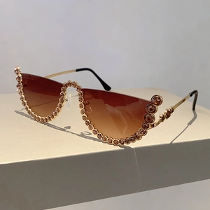 Detail view of semi-rimless sunglasses with gold frames and brown gradient rhinestone lenses