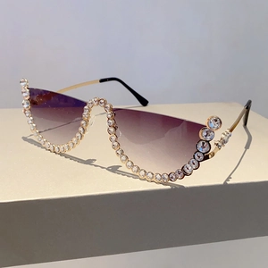 Detail of half-rim sunglasses with purple gradient lenses and sparkling rhinestones
