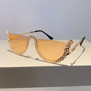 Macro view of semi-rimless amber sunglasses featuring sparkling rhinestones and gold temples