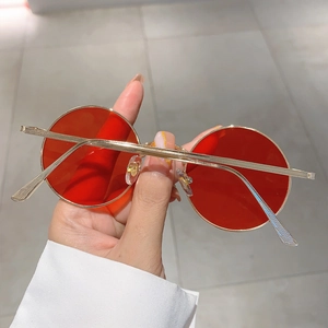 Detail of retro round red lenses with minimalist gold metal frame and slim temples