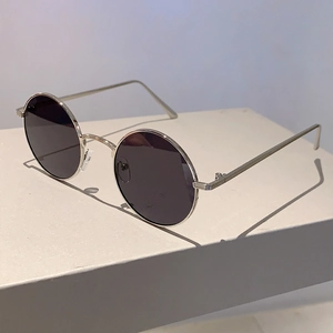 Macro detail of retro round silver metal frame sunglasses with dark grey lenses