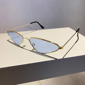 Close-up of retro cat-eye sunglasses with thin gold metal frame and blue tinted lenses
