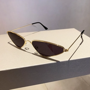 Detail of vintage cat-eye metal sunglasses with gold frame and dark lenses on a display box
