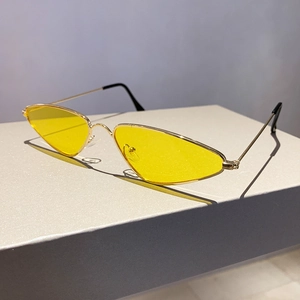 Close-up of retro triangle sunglasses with yellow lenses and golden metal frame
