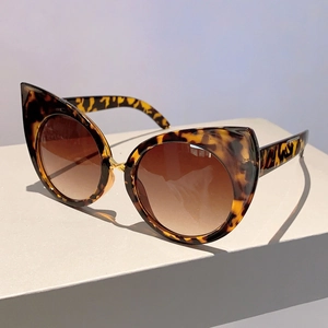 Detail view of retro cat-eye sunglasses with tortoiseshell frame and gradient brown lenses