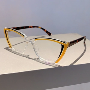 Dettaglio montatura cat-eye alla moda con giunzione giallo-nera e aste tartarugate