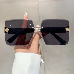 Detail of rimless gradient sunglasses with gold metal rose accents on lens corner