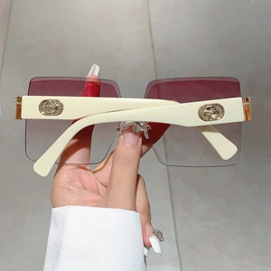 Detail showing creamy white temples with an elegant golden rose relief on sunglasses