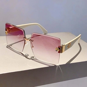 Detail of rimless gradient purple lenses with elegant gold rose accents and ivory temples