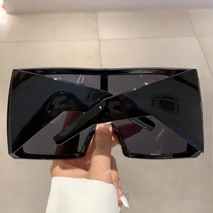 Vue macro de lunettes de soleil futuristes noires oversize avec finition polie brillante