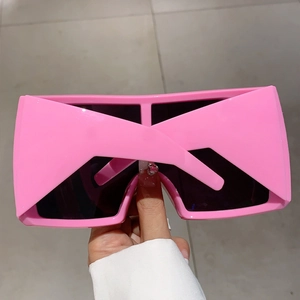 Détail de lunettes de soleil de sport Y2K rose vif avec monture épaisse et verres foncés