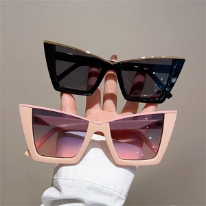 Detail view of cat-eye sunglasses in black and pink frames with gradient lenses