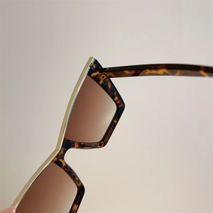 Detail of tortoise shell frames with gold metal trim and brown gradient lenses