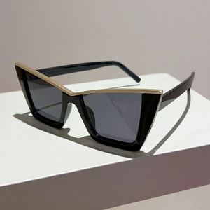 Detail of trendy black cat-eye sunglasses with elegant V-shaped golden metal inlay decoration
